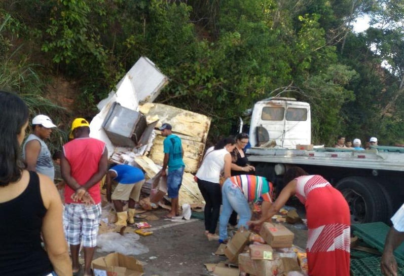 Caminhão capota e carga é saqueada