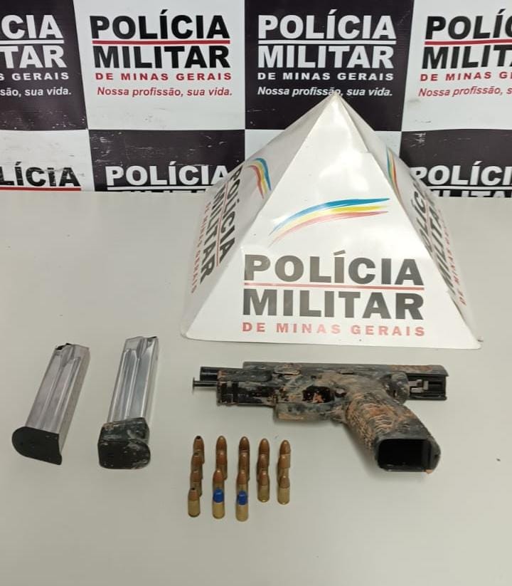 Pistola calibre .9, 18 munições e o carregador da arma em cima de mesa de registro de materiais apreendidos da PM