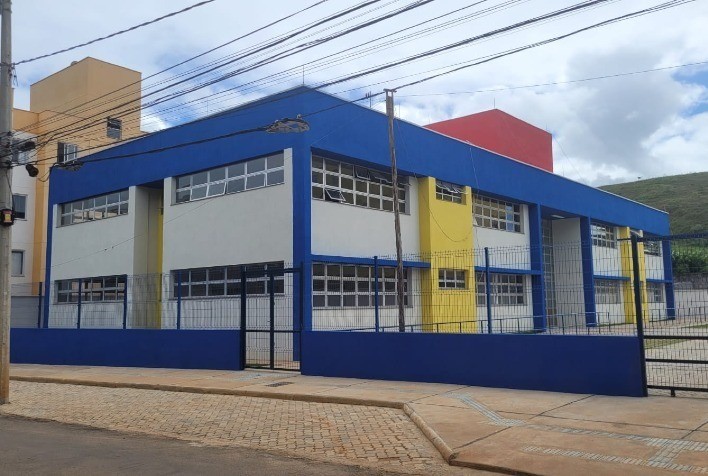 CMEI Cônego Antônio Mendes: Imagem na diagonal de toda a creche reformada. Predominância de pilares e paredes azuis e amarelas em meio a base branca.