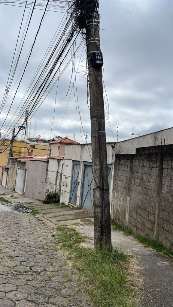 Imagem ilustrativa de poste na Av. Juscelino Kubishek com cabos soltos e algns amarrados. 

lei que obriga empresas a identificar cabos soltos é sancionada