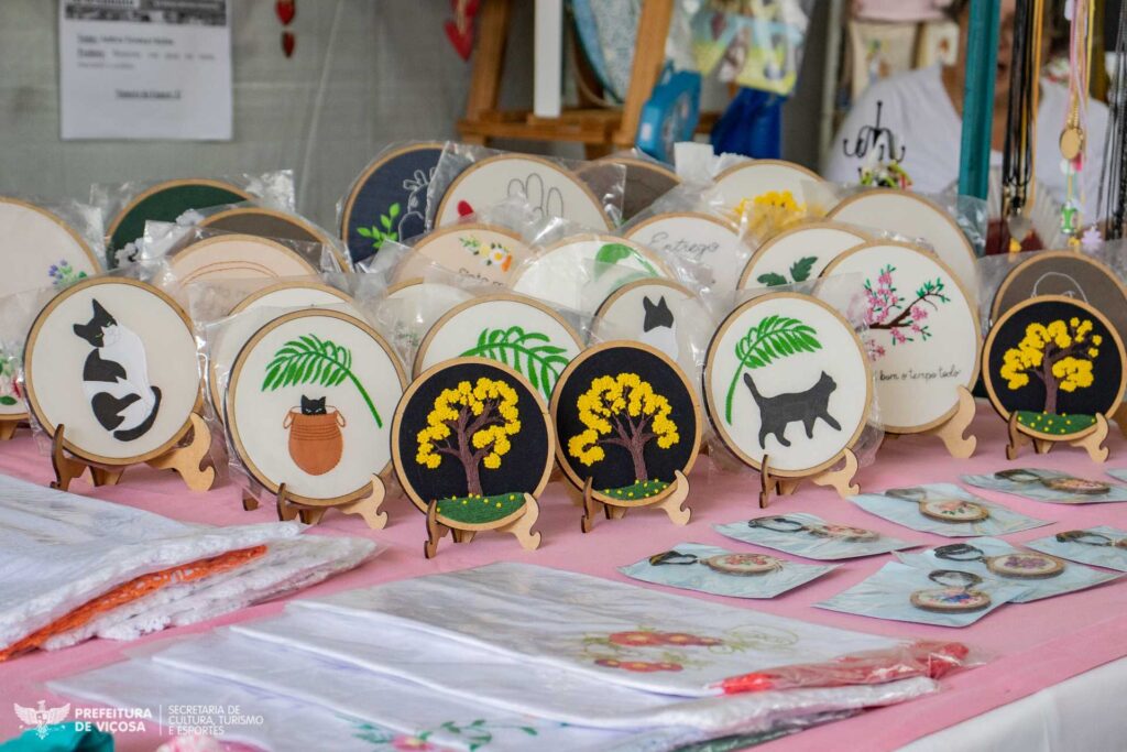Feira de Artesanato, especial do Dias das Mães.
Imagem ilustrativa da feira do artesanato de março. Rodelas de pano decorativas com bordados de gatos e plantas diversas.